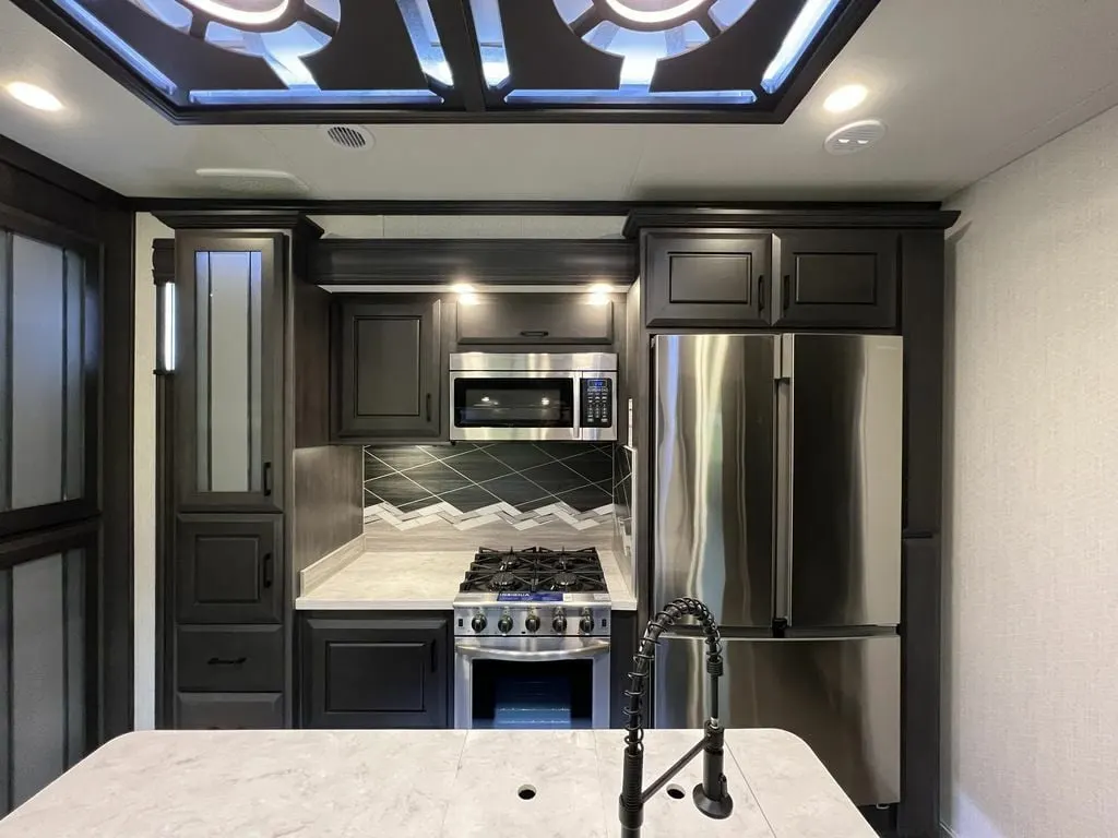 Kitchen with a gas burner, fridge, oven, sink and cabinets.