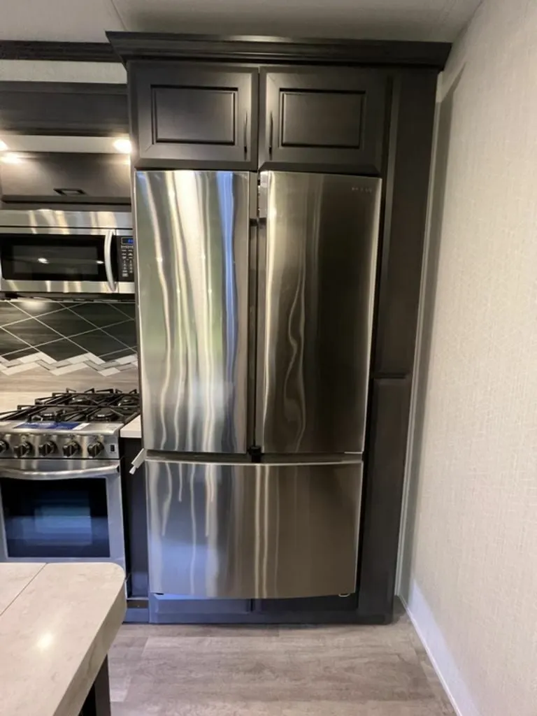 Kitchen with a gas burner, fridge, and oven.