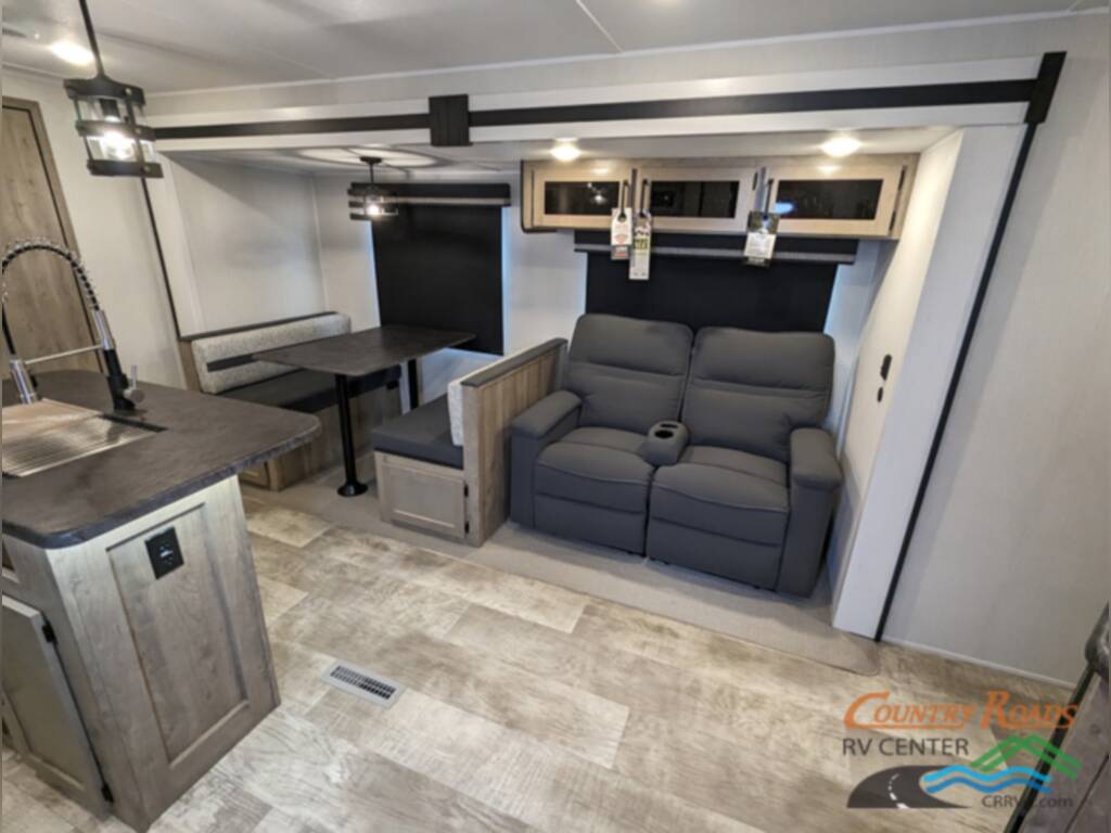 Interior of the RV with a dinette, sofas and a kitchen.