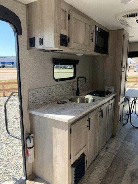 Kitchen with a gas burner, oven, sink and cabinets.