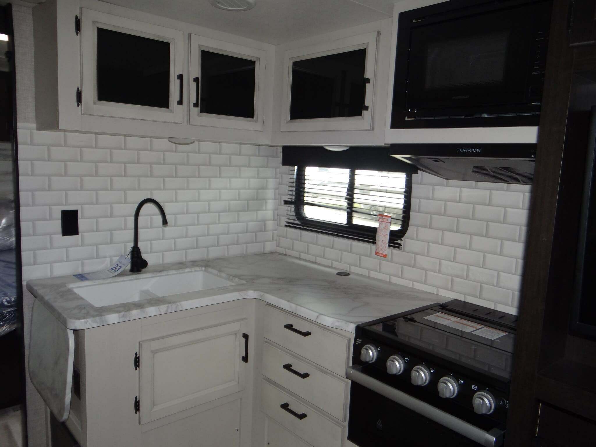 Kitchen with a gas burner, oven, sink and cabinets.