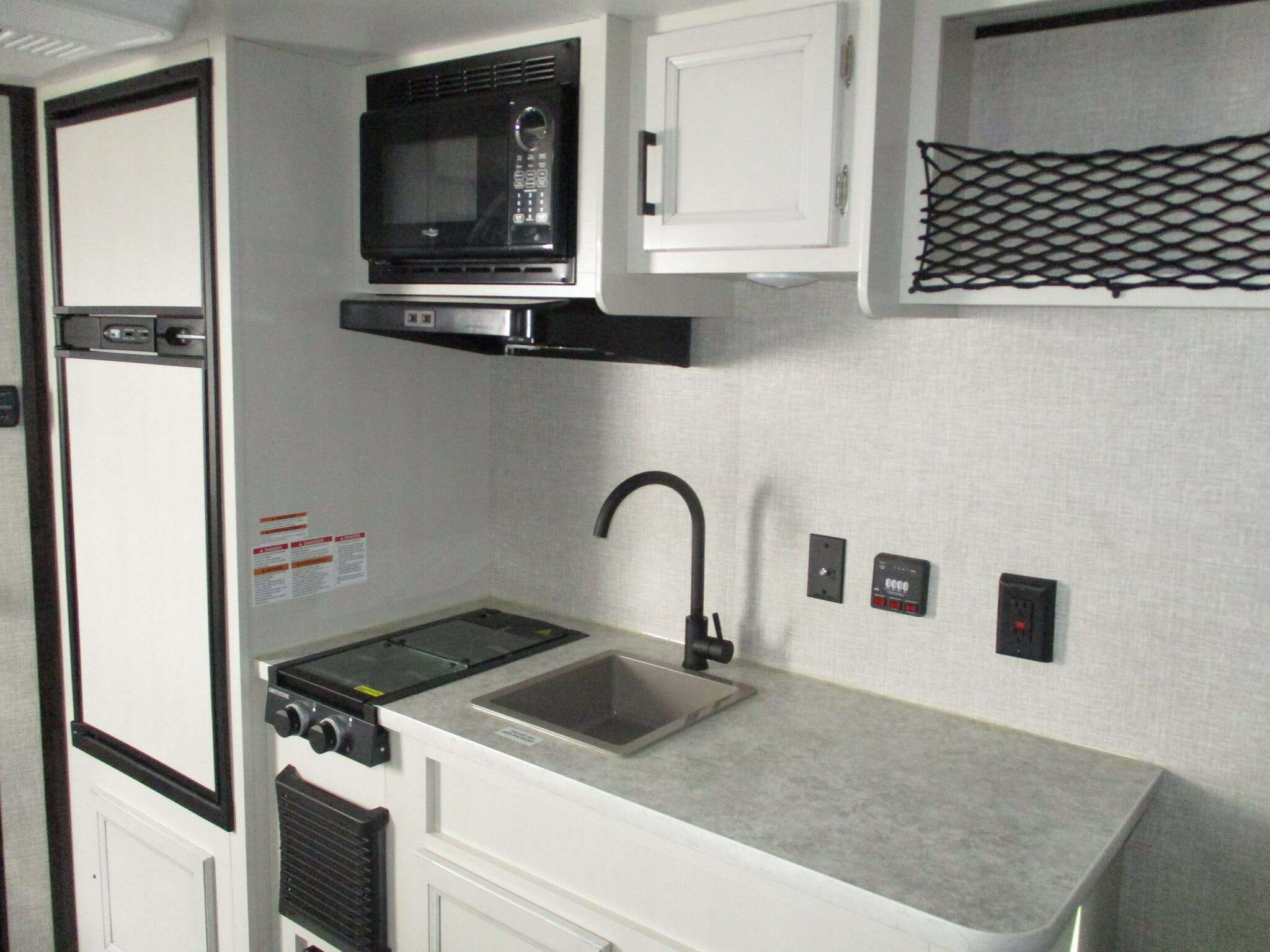 Kitchen with a gas burner, fridge, oven, sink and cabinets.