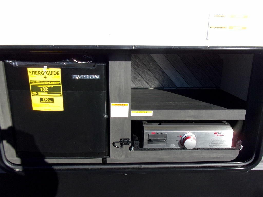 Outside kitchen with a fridge and a griddle.