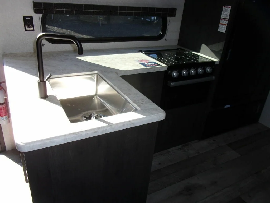 Kitchen with a gas burner, sink and cabinets.