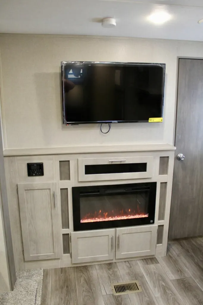 Entertainment center with a TV and a fireplace.