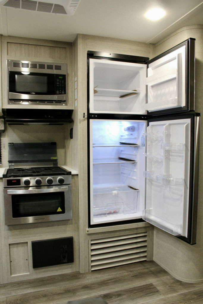 Kitchen with a gas burner, fridge, and oven.