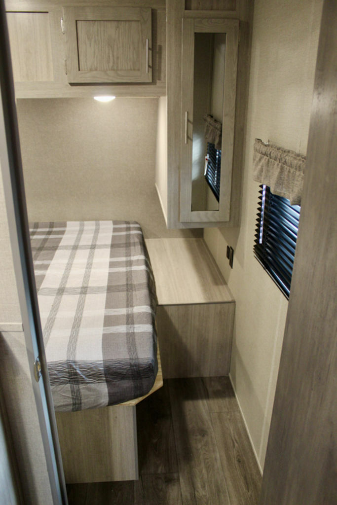 Bedroom with a queen size bed, overhead cabinets and shirt closets.