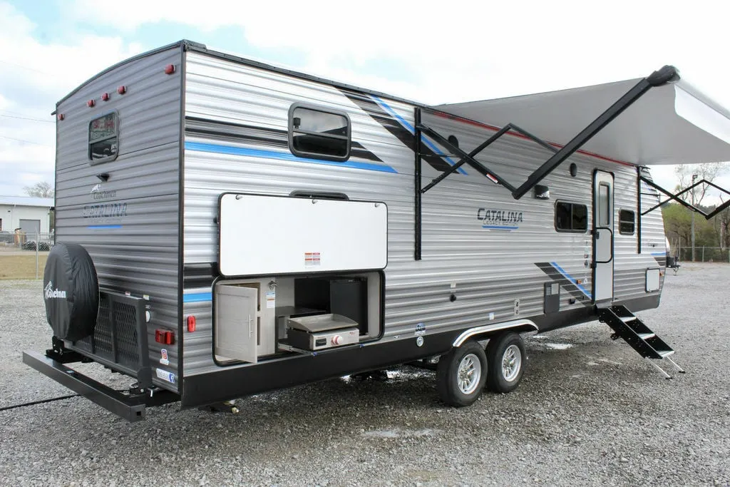 Side view of the RV with outdoor kitchen and an awning