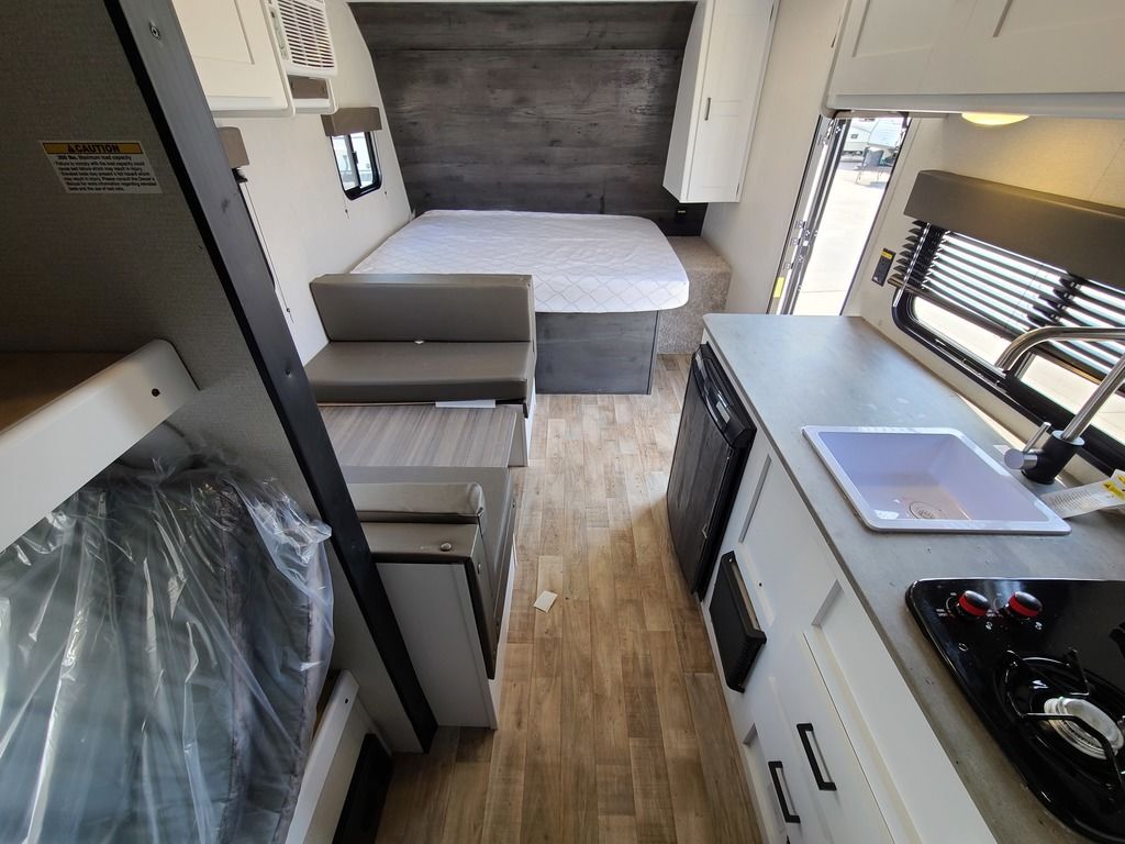 Interior view of the RV with a dinette, bedroom and a kitchen.