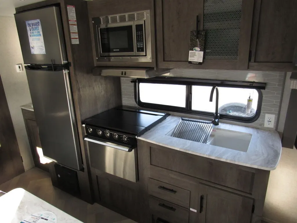 Kitchen with a gas range, fridge, oven, sink and cabinets.