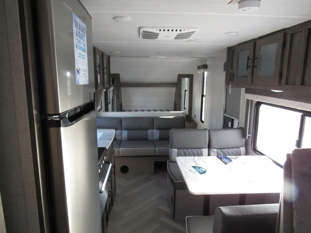 Interior view of the RV with a dinette, living space and a kitchen.