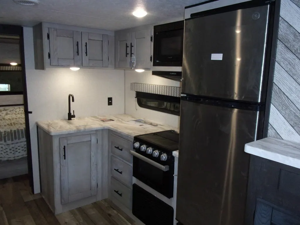 Kitchen with a gas burner, fridge, oven, sink and cabinets.