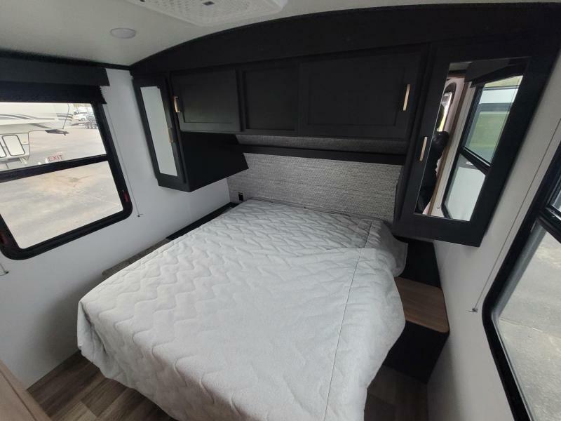 Bedroom with a queen size bed, overhead cabinets and shirt closets.