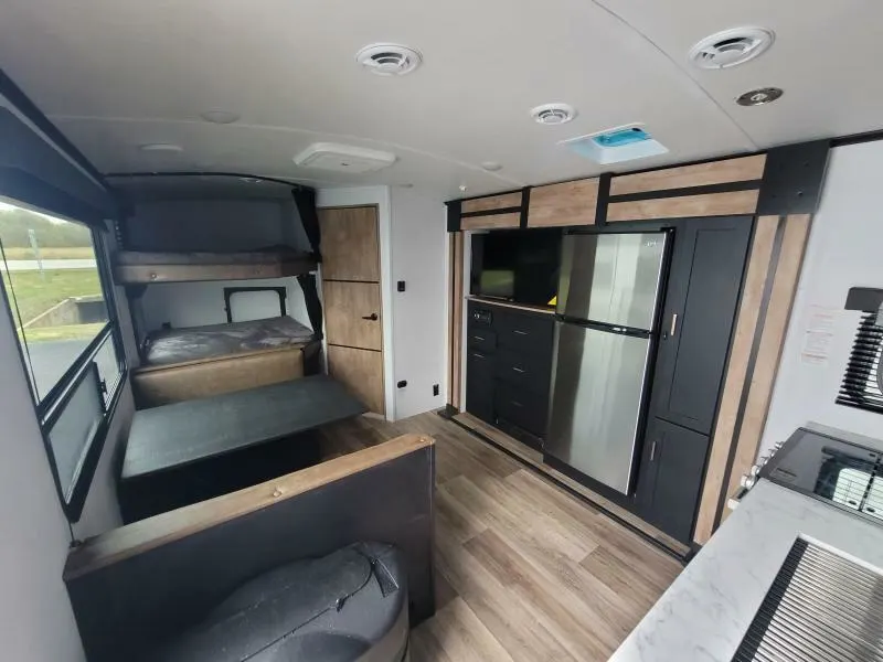 Interior view of the RV with a dinette, bedroom and a kitchen.