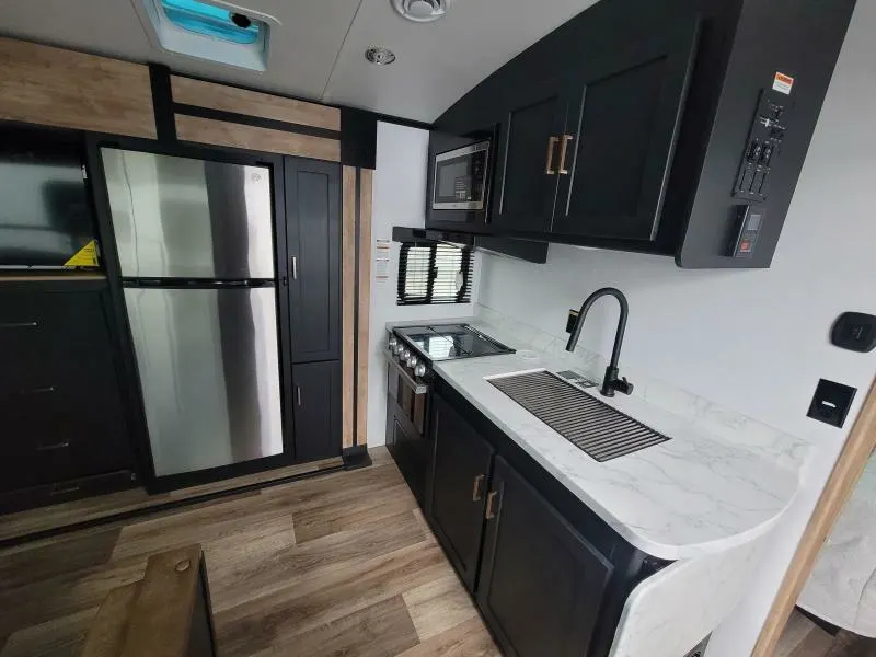 Kitchen with a gas burner, fridge, oven, sink and cabinets.