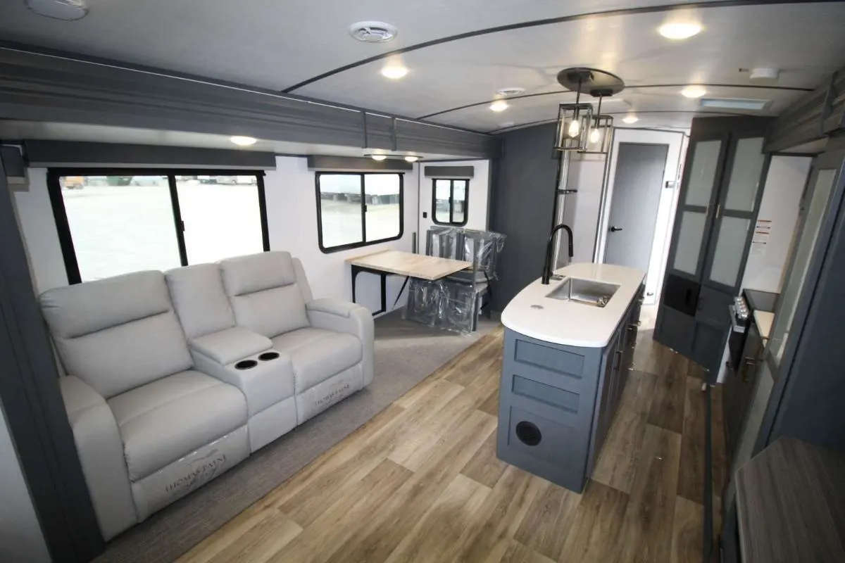 Interior view of the RV with a dinette, living space and a kitchen.