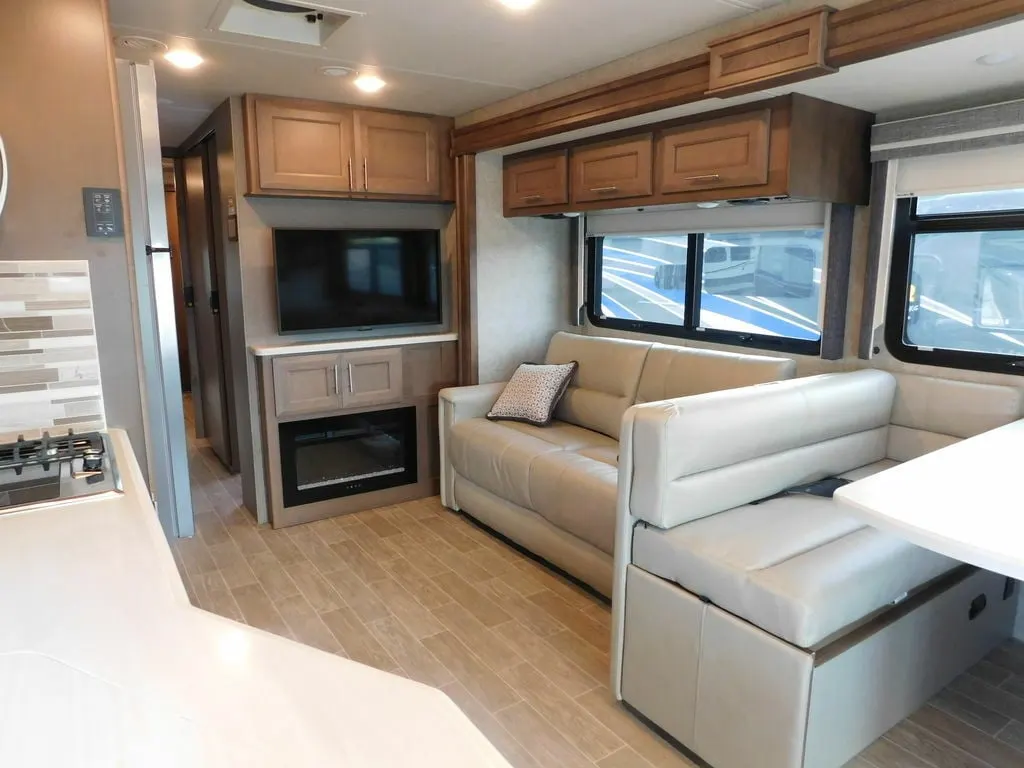 Living space with leather seats and overhead cabinets. 