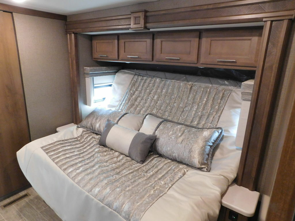 Bedroom with a king size bed and overhead cabinets.