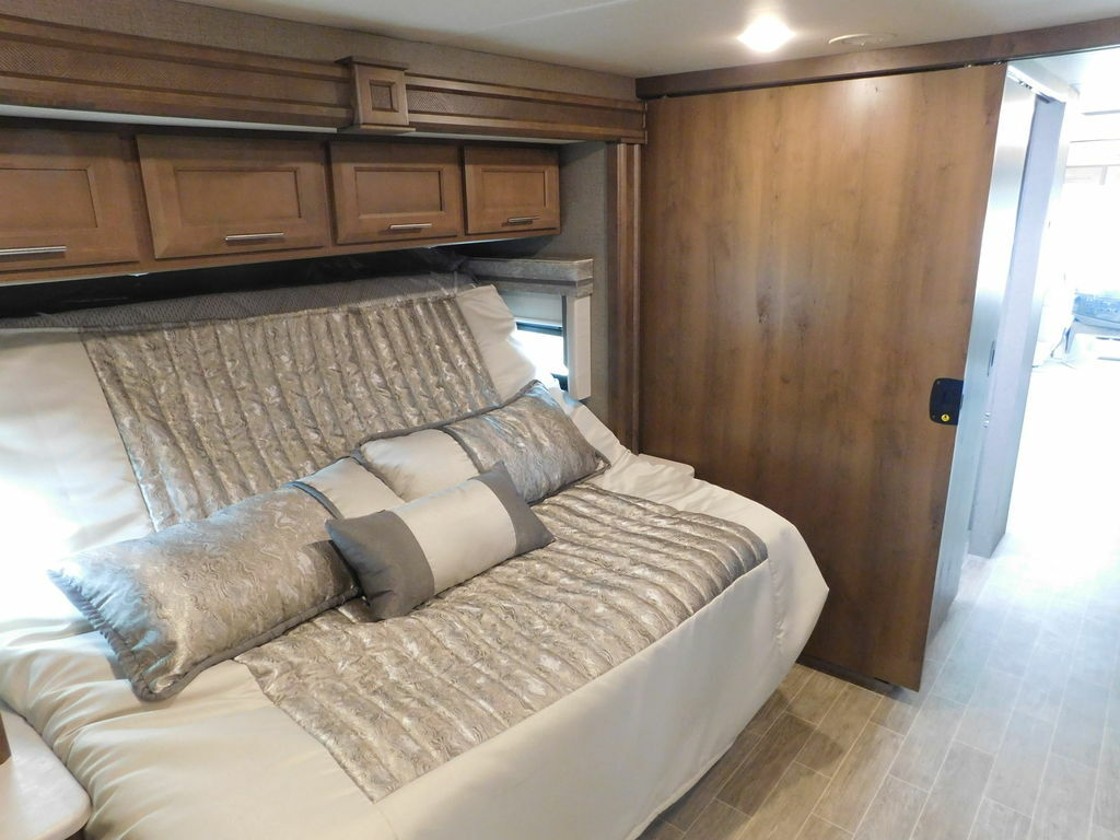 Bedroom with a king size bed and overhead cabinets.