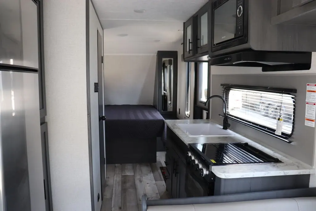 Interior view of the RV with a bedroom and a kitchen.