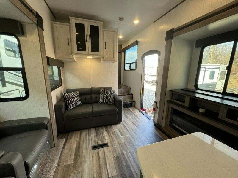 Living space with leather seats and overhead cabinets. 