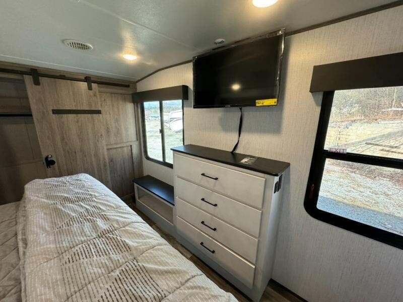 Bedroom with a king size bed, dresser, TV and a closet.