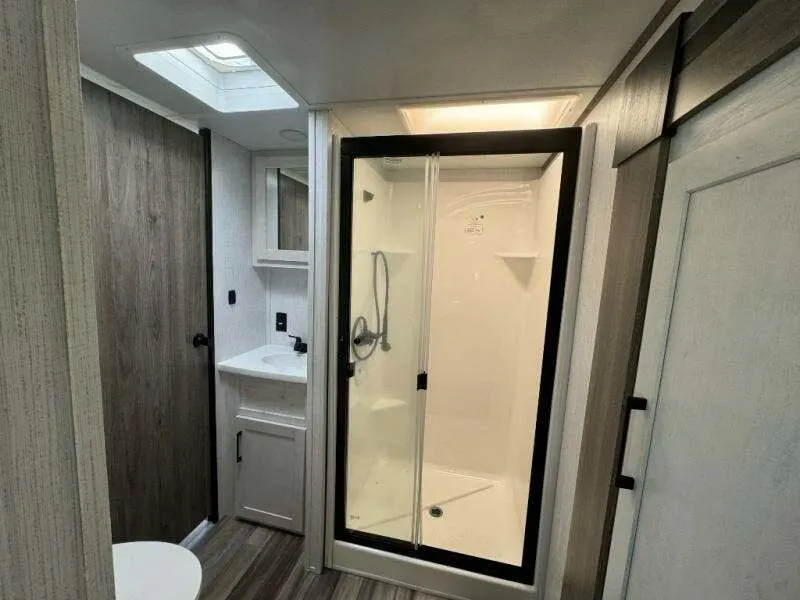 Bathroom with a sink, toilet and a walk-in shower.