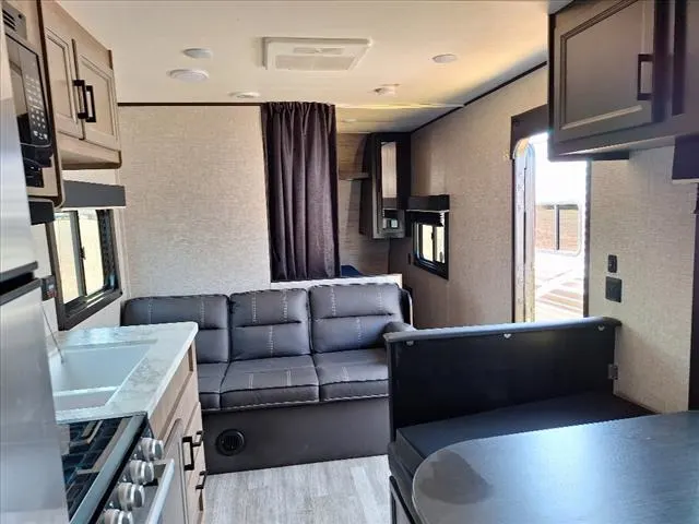 Interior view of the RV with a dinette, living space and a kitchen.