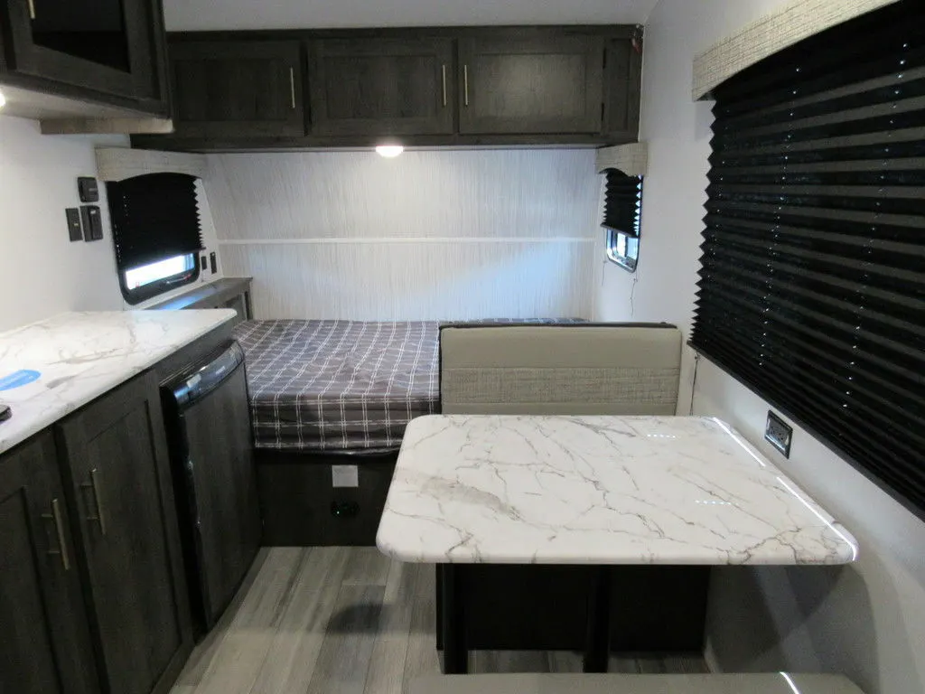 Interior view of the RV with a dinette, bedroom and a kitchen.