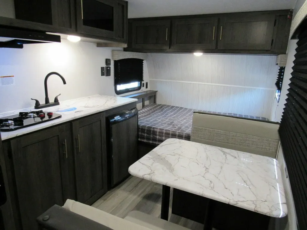 Interior view of the RV with a dinette, bedroom and a kitchen.