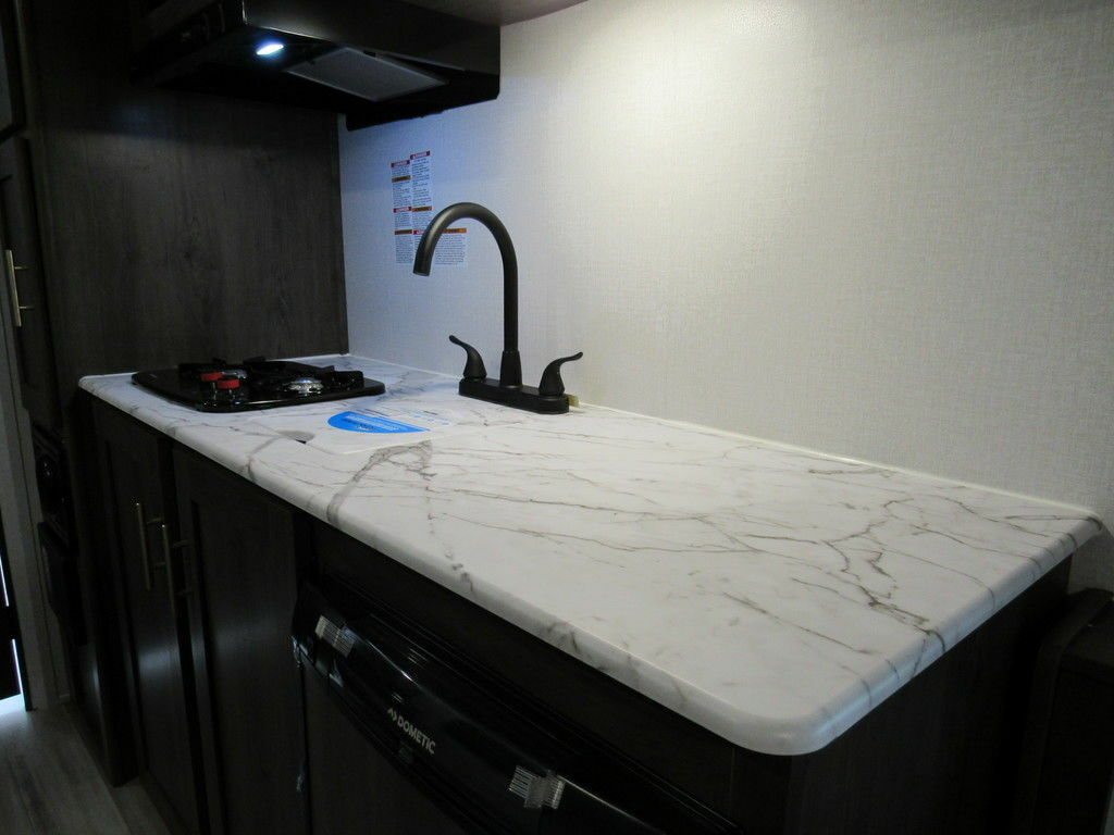 Kitchen with a gas burner, sink and cabinets.