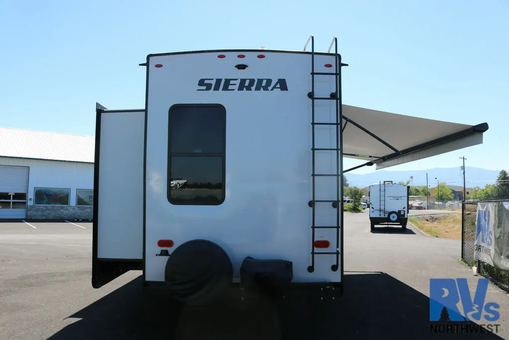 Rear view of the RV with an awning and a slide out.