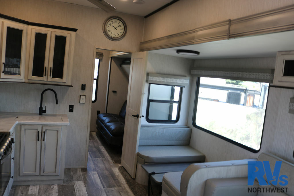 Interior view of the RV with a dinette, living space and a kitchen.