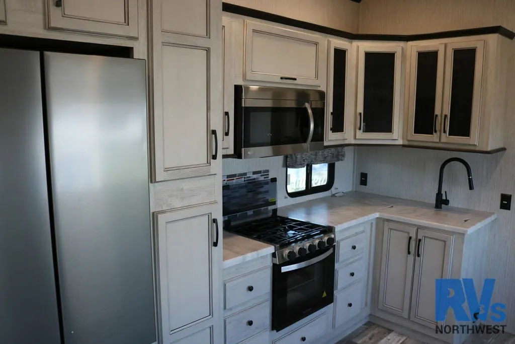 Kitchen with a gas burner, fridge, oven, sink and cabinets.