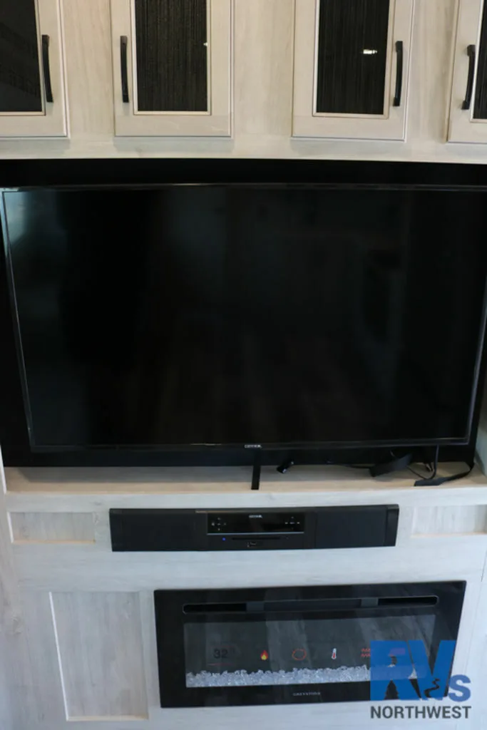 Entertainment center with a TV and a fireplace.