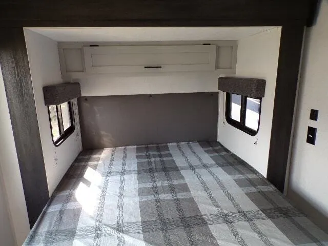 Bedroom with a queen size bed and overhead cabinets.