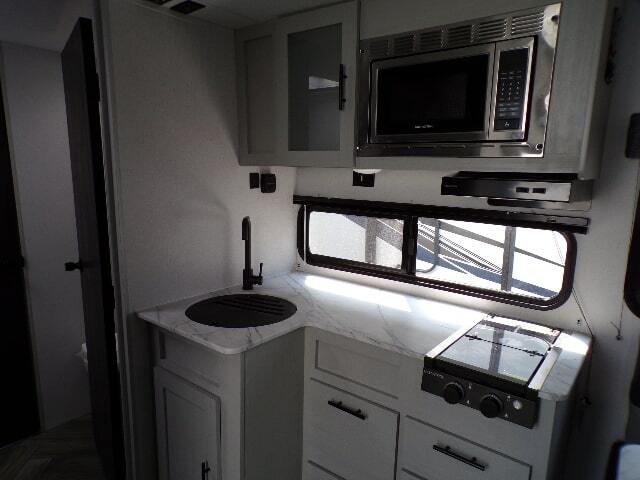 Kitchen with a gas burner, oven, sink and cabinets.