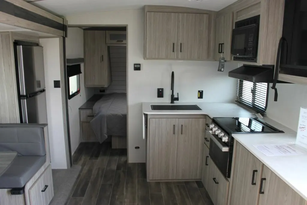 Interior view of the RV with a dinette, bedroom and a kitchen.