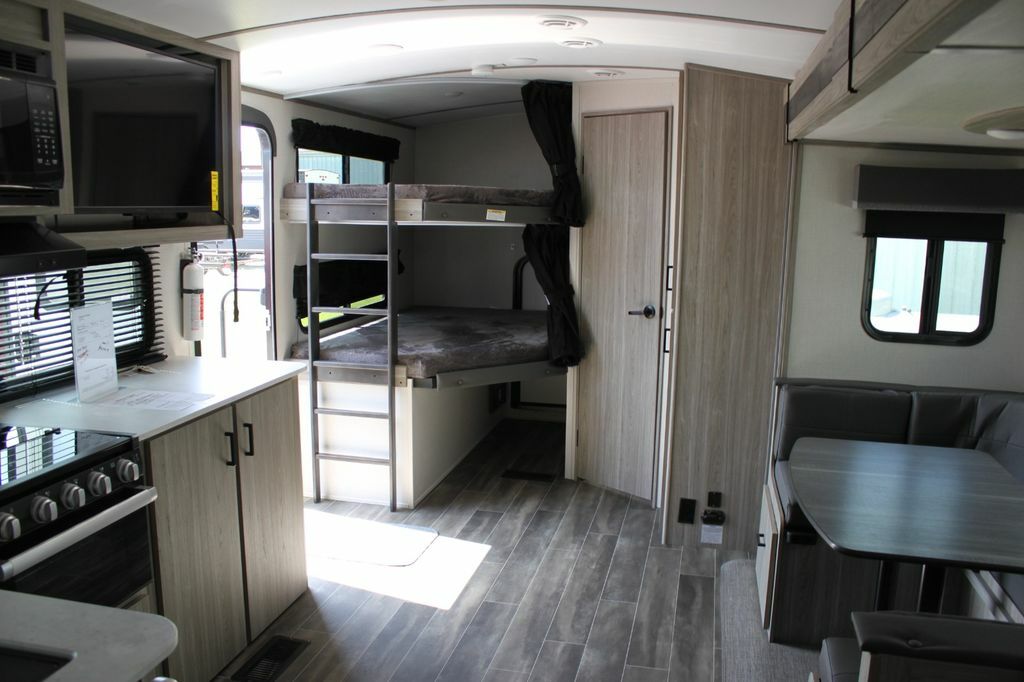 Interior view of the RV with a dinette, bedroom and a kitchen.