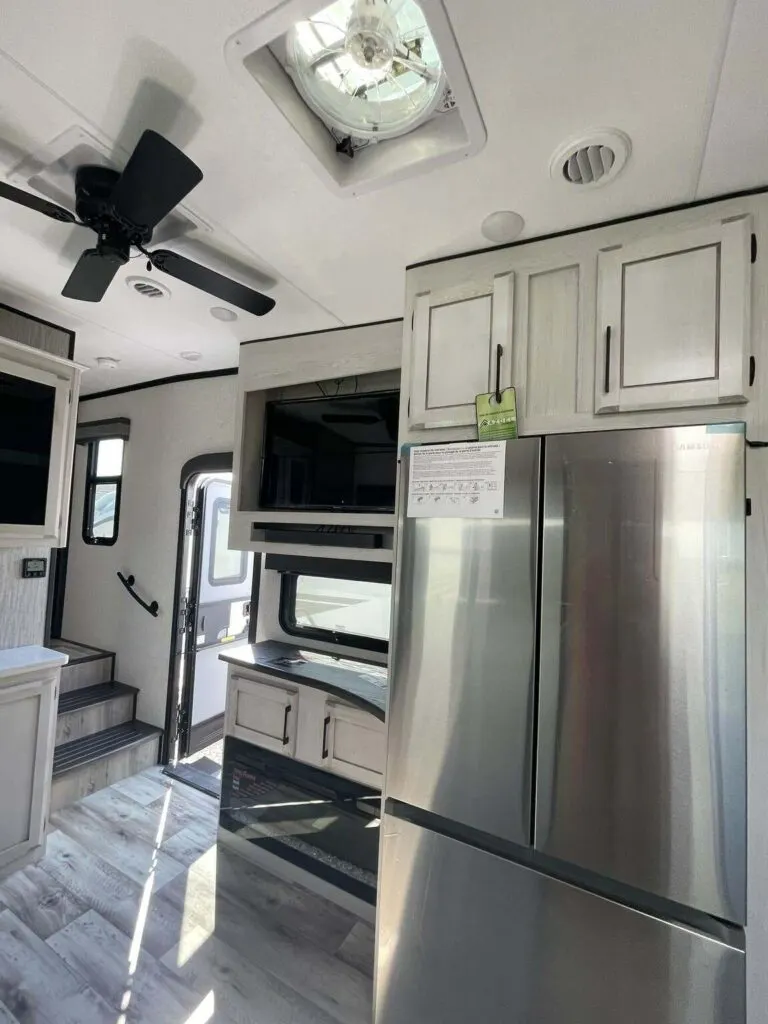 Entertainment center flanked by the fridge.