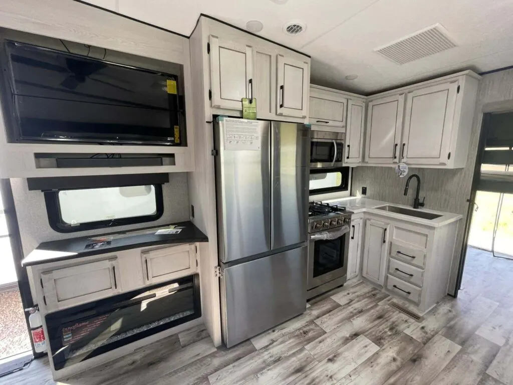 Kitchen with a gas burner, fridge, oven, sink and cabinets.