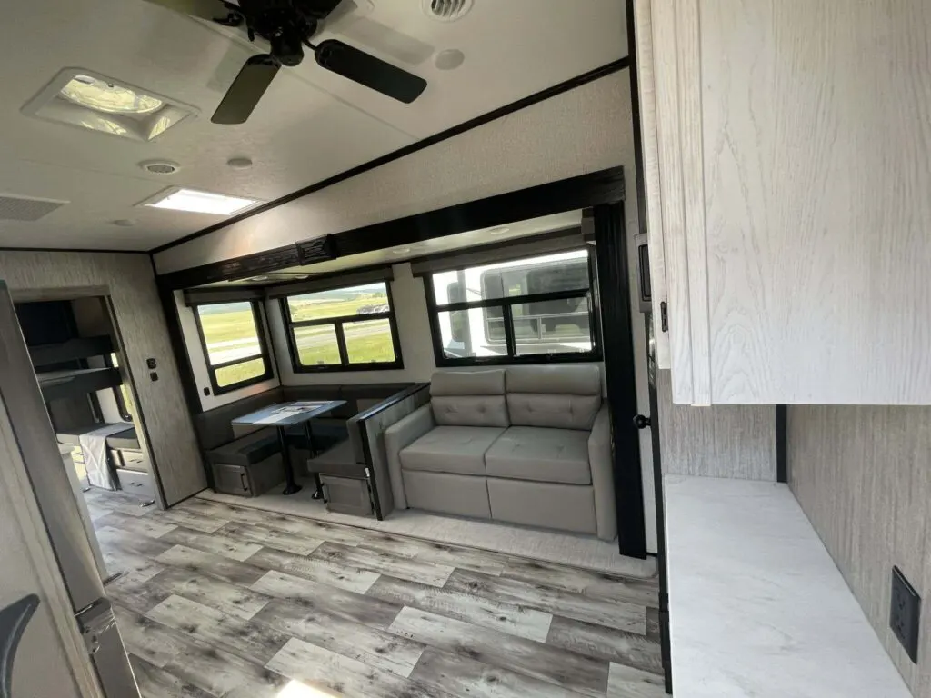 Interior view of the RV with a dinette and a living space.