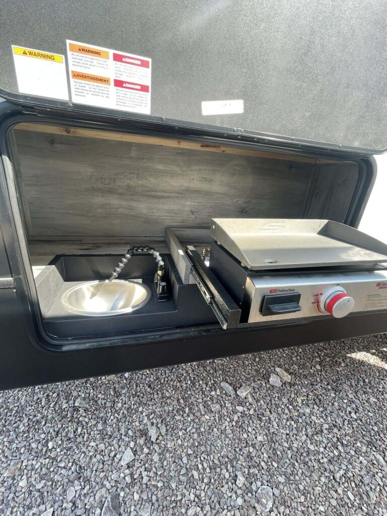 Outdoor kitchen with a gas burner and a sink.