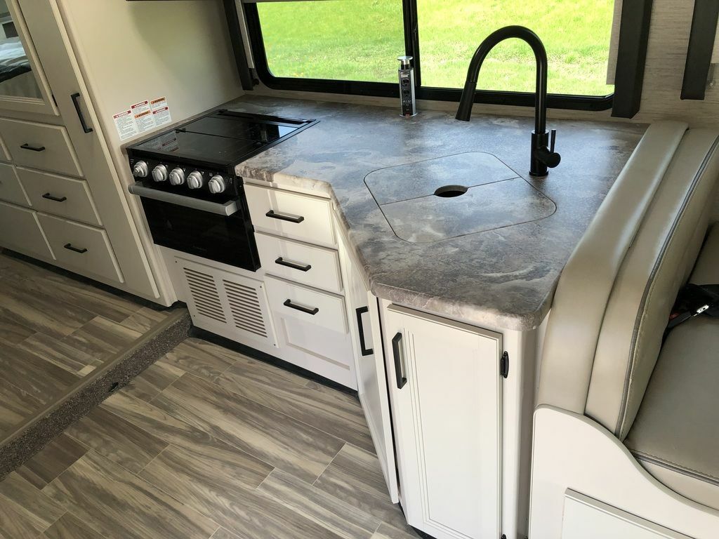 Kitchen with a gas burner, sink and cabinets.