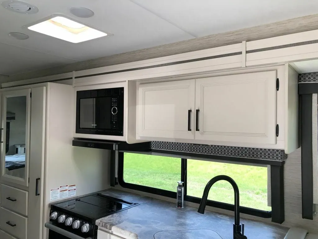 Kitchen with a gas burner, oven, sink and cabinets.