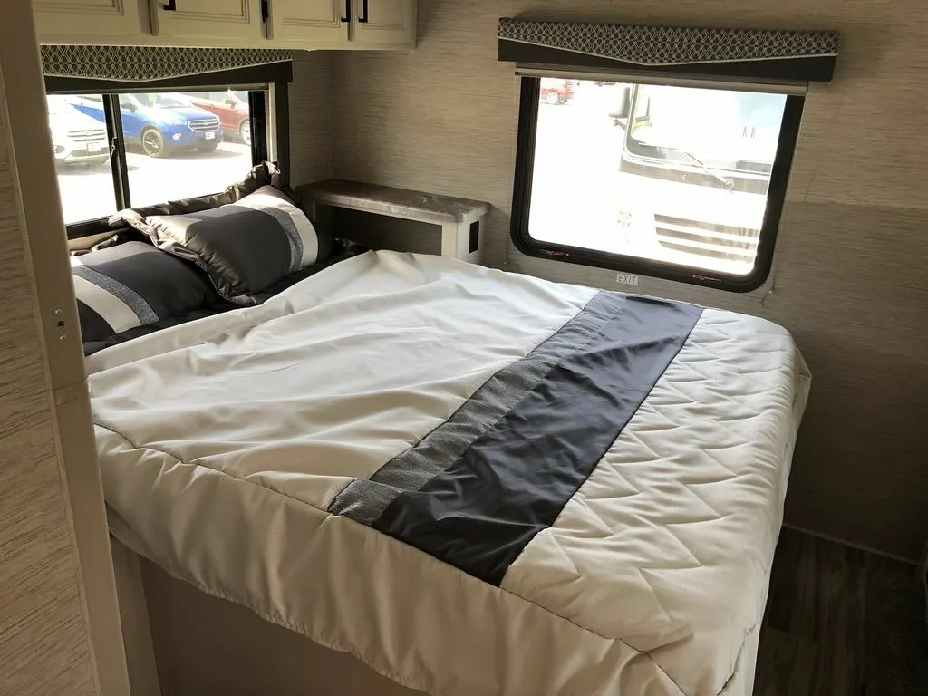 Bedroom with a queen size bed and overhead cabinets.