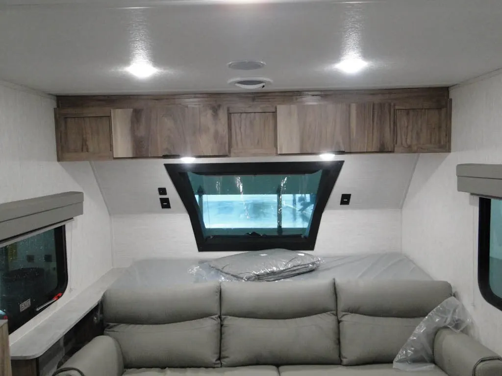 Living space with leather seats and overhead cabinets.