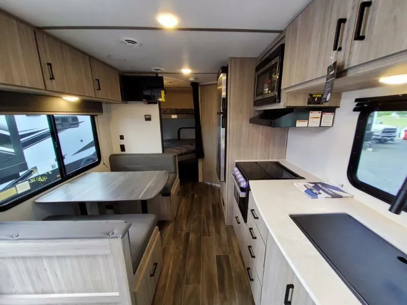 Interior view of the RV with a dinette, bedroom and a kitchen.