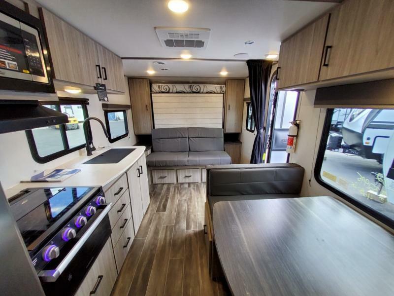 Interior view of the RV with a dinette, living space and a kitchen.