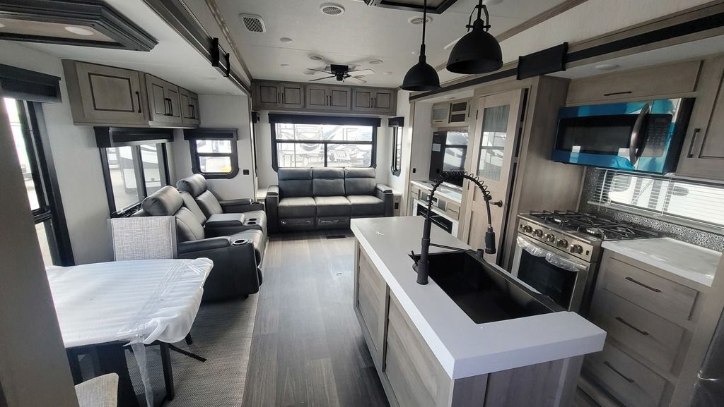 Interior view of the RV with a dinette, living space and a kitchen.